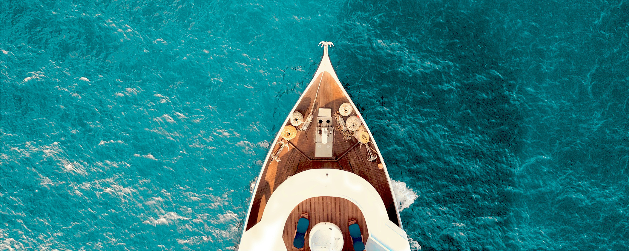 Aerial view of a small boat navigating through the deep blue ocean waters.